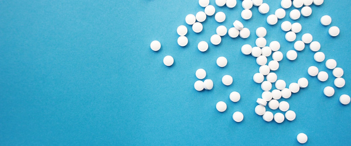 NHS pharmacy services - tablets on an NHS-blue background at Barons Court Pharmacy
