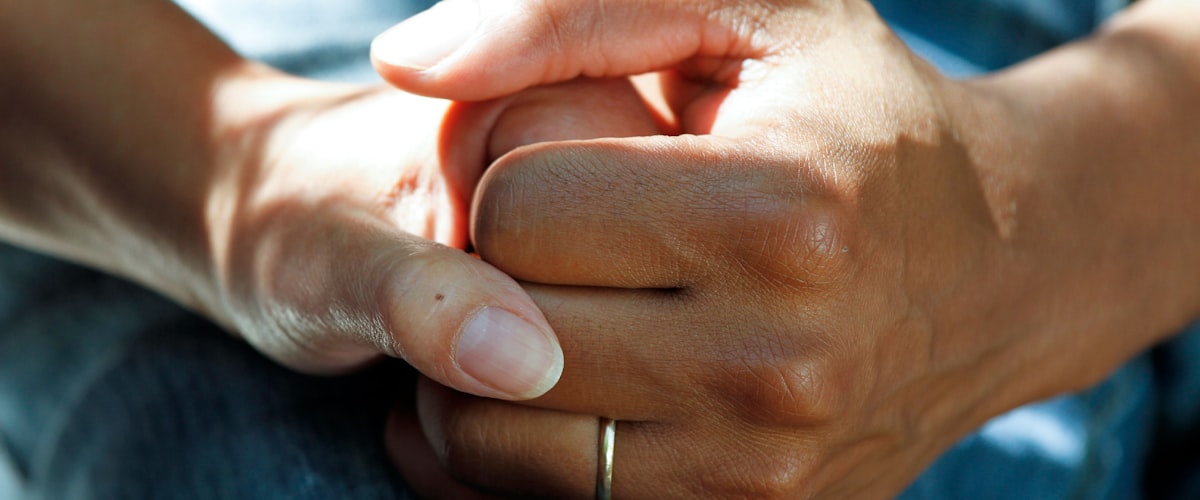 Pharmacist holding a patient's hands - caring, confidential support at Barons Court Pharmacy